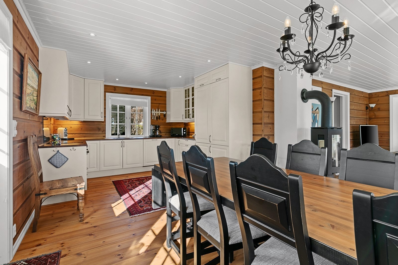 Kjøkkeninnredningen har hvite, profilerte fronter og integrerte hvitevarer. Galleribilde