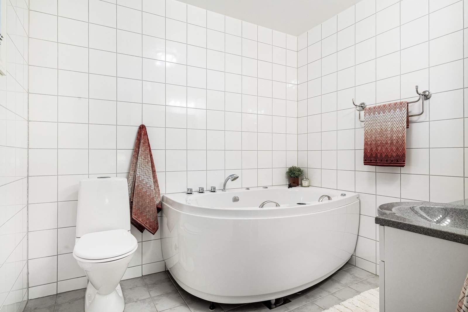 Hovedbadet er pent belagt med flis på gulv og vegger. Det er vannbåren varme i gulvet. Galleribilde