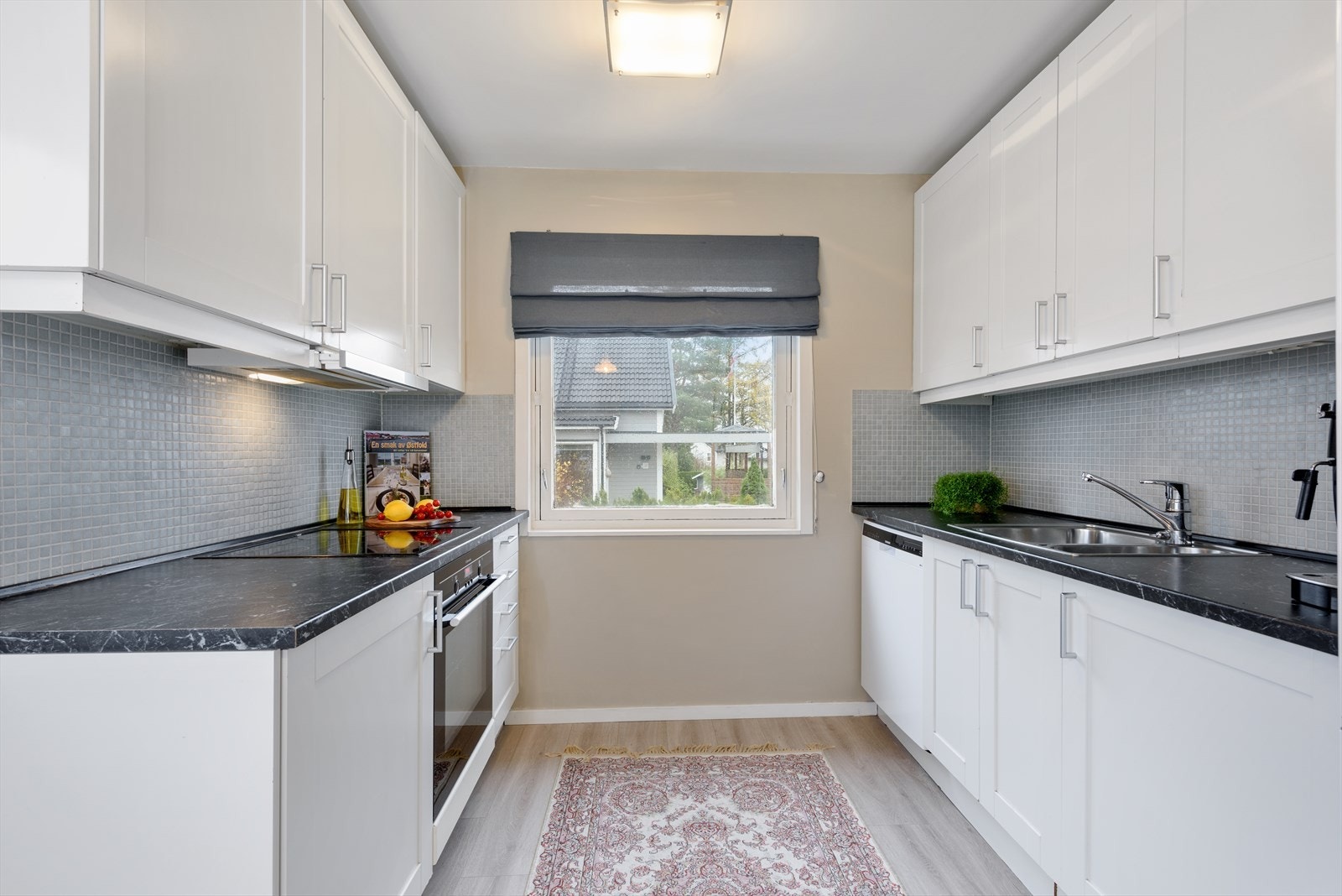 Over benk er det mosaikkflis på vegg. Hvitevarene som medfølger består av integrert platetopp og stekeovn, ventilator og underbygget oppvaskmaskin. Galleribilde