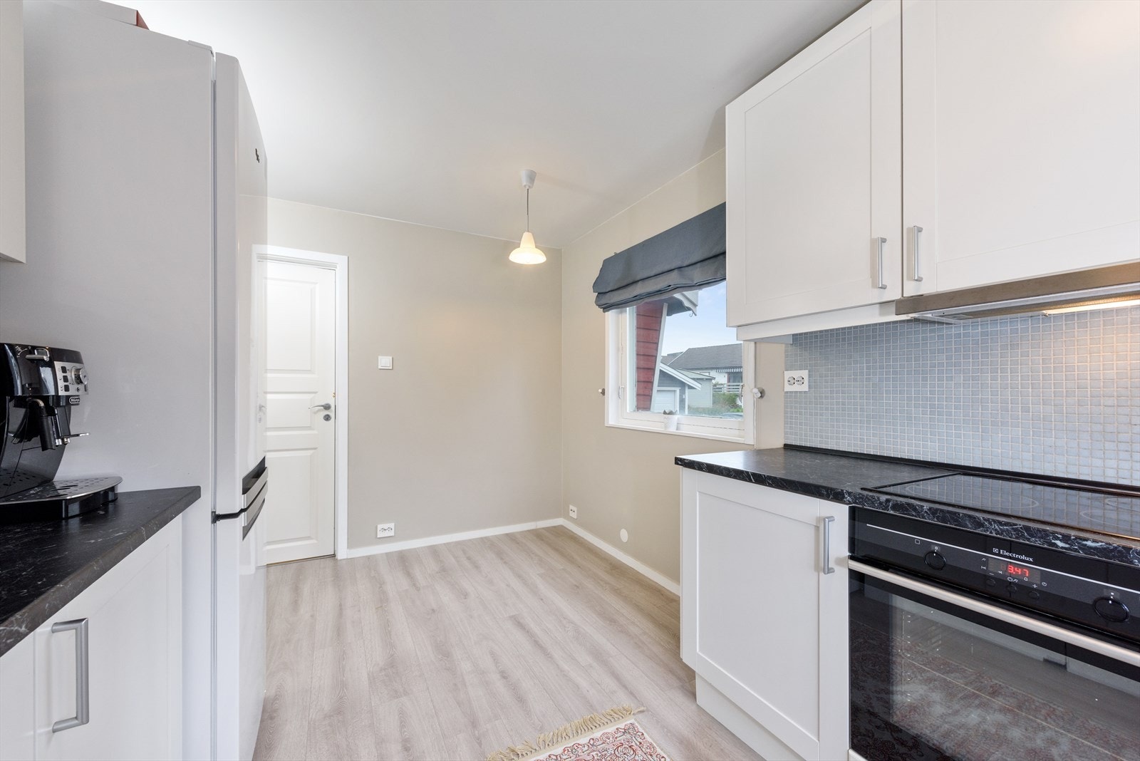 Rommet har to store vinduer som slipper inn naturlig lys, og det er plass til frokostbord under vindu mot fremside av boligen. Galleribilde