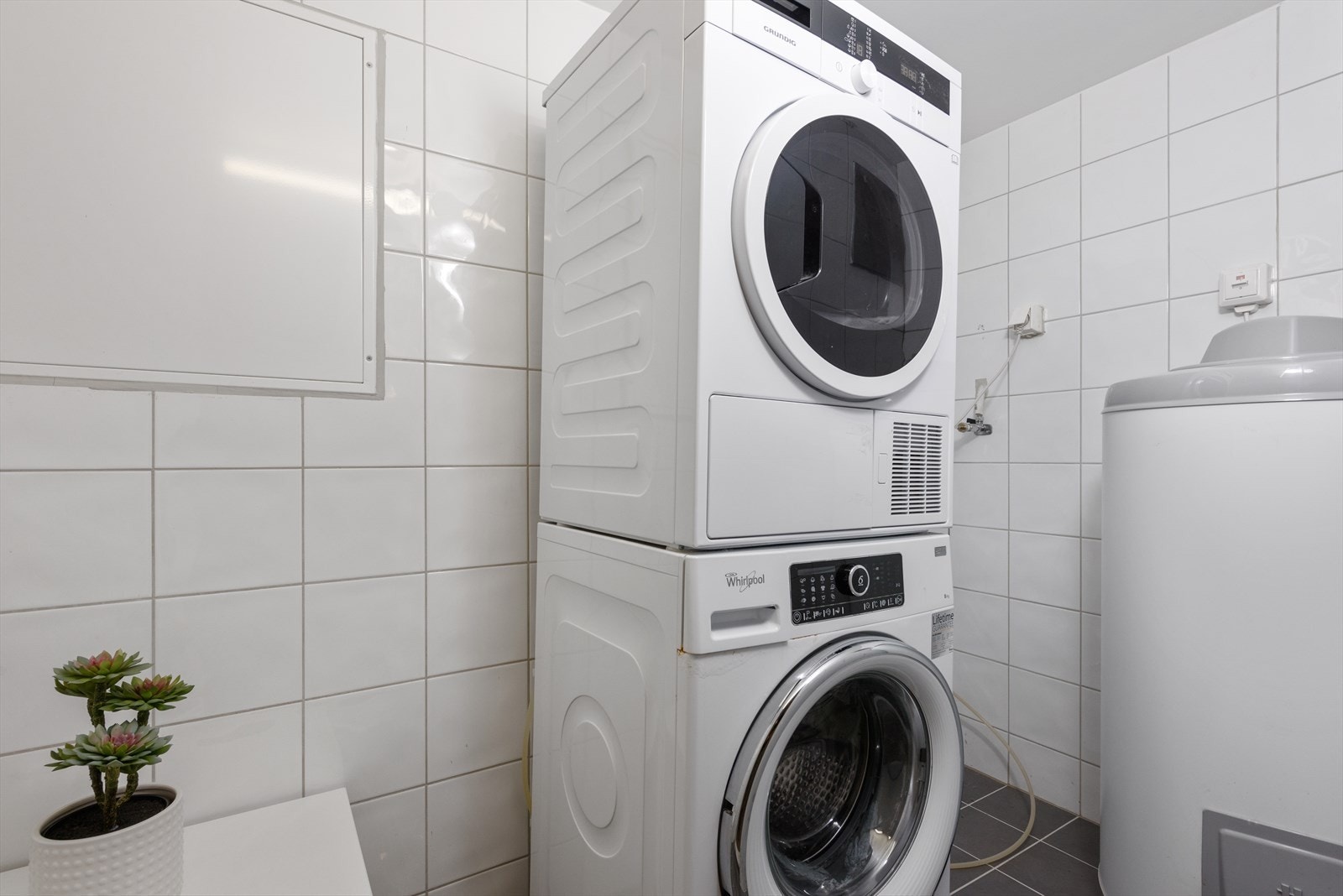 Vaskerommet er kombinert teknisk rom, med flislagte gulv og vegger, røropplegg for vaskemaskin og plass til tørketrømmel. Galleribilde