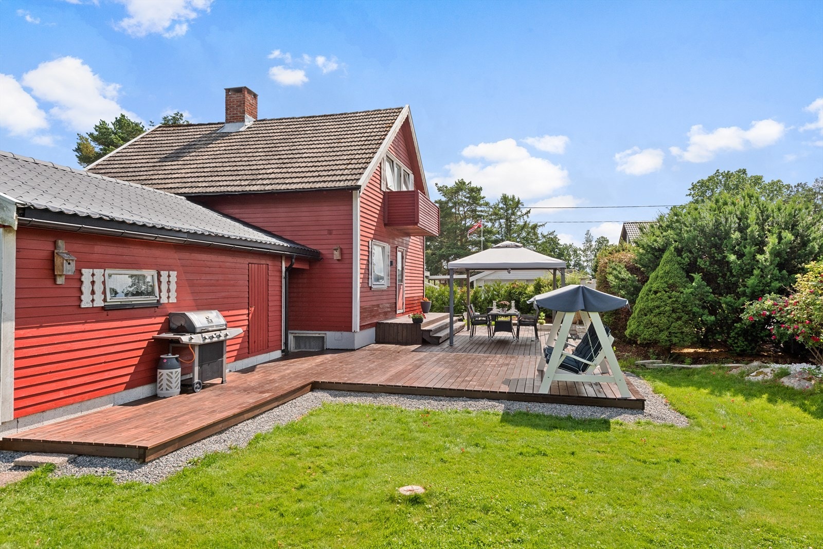 Tomten er pent opparbeidet med grønn hageplen, hekk, busker, div. beplantning, lekestue og sandkasse. Galleribilde