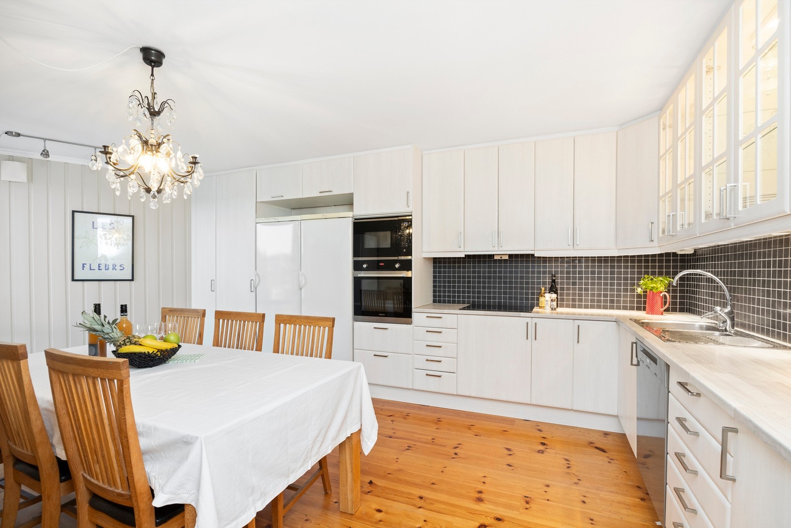 Leiligheten har et stort kjøkken i eget rom med plass til spisebord. Galleribilde