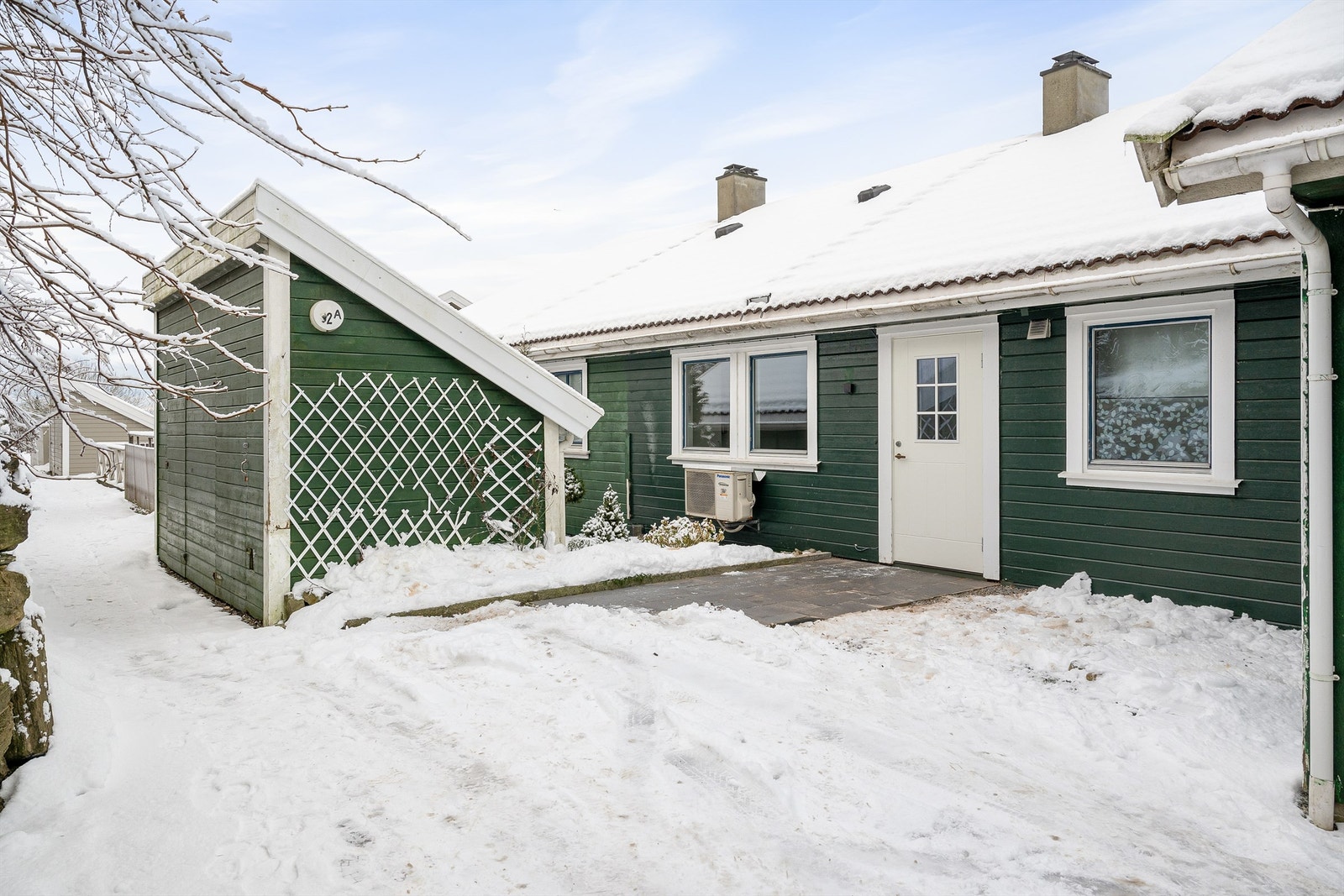 Inngangsparti og egen utebod (halvdel nærmest egen inngangsdør. Det er godkjent av sameiet å sette opp levegg ut fra vegg til carport, samt gjerde med port foran inngangsdøren om ønskelig. Galleribilde