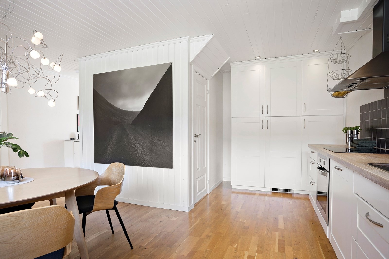 Kjøkkeninnredningen er hvit med profilerte fronter og benkeplate i heltre. Hvitevarer som kjøleskap, oppvaskmaskin, induksjonstopp og stekeovn medfølger handelen. Galleribilde