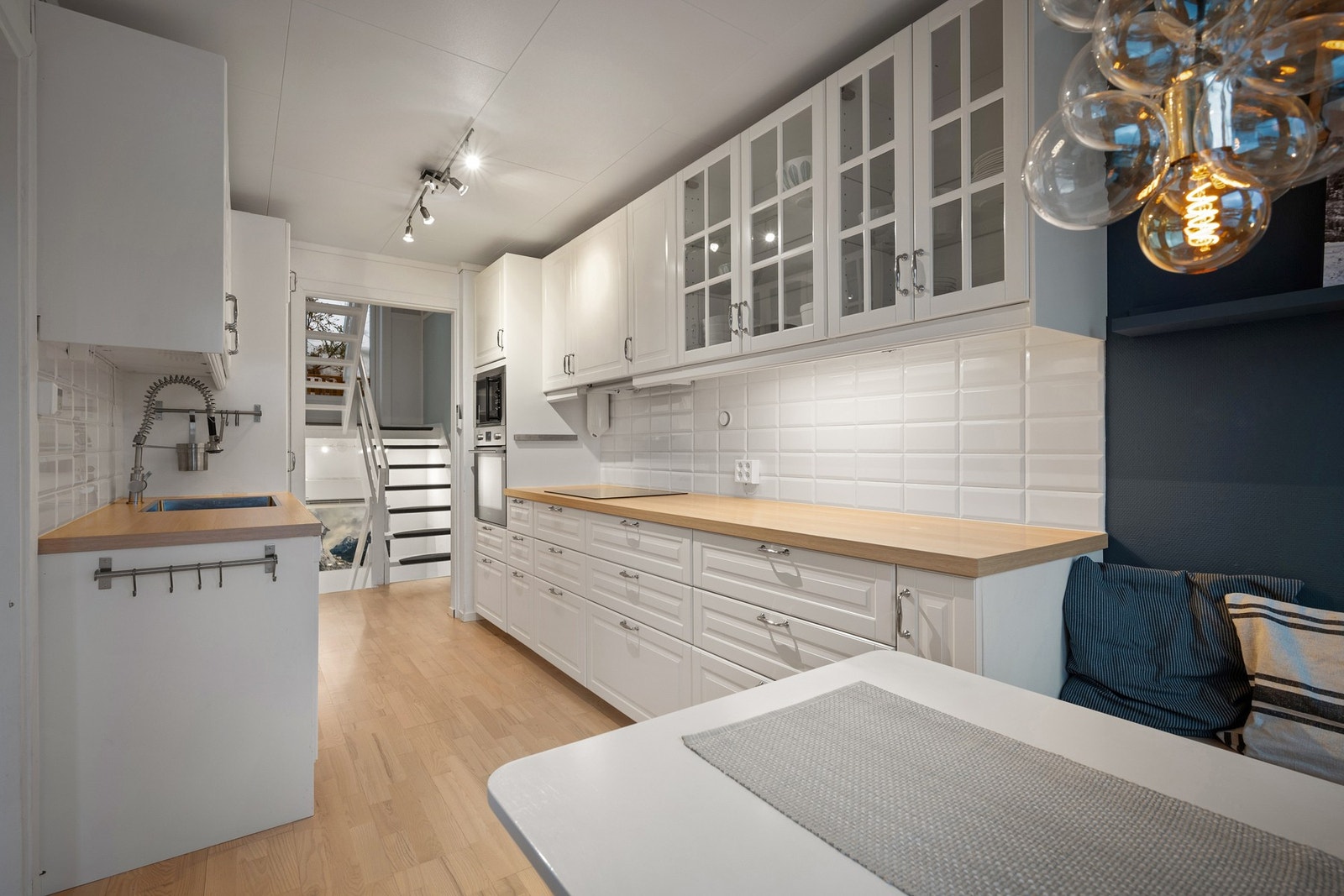 Pent og tidløst kjøkken med hvite profilerte fronter og lys benkeplate Galleribilde