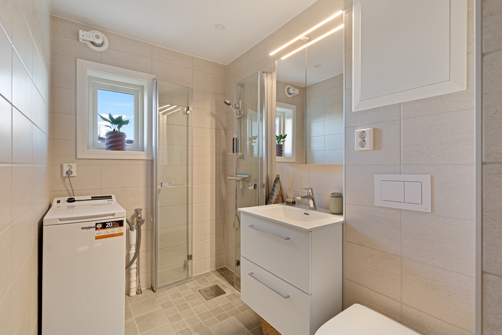 Leiligheten fikk nytt bad i 2024 - moderne og funksjonelt utformet med beige fliser på gulv og vegger, downlights, gulvvarme og vindu som slipper inn naturlig lys. Galleribilde