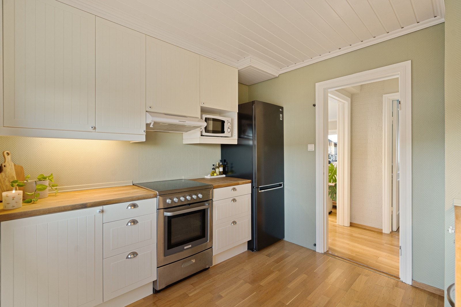 Videre er kjøkkenet utstyrt med ventilator over komfyrplassen og integrert oppvaskmaskin. Galleribilde