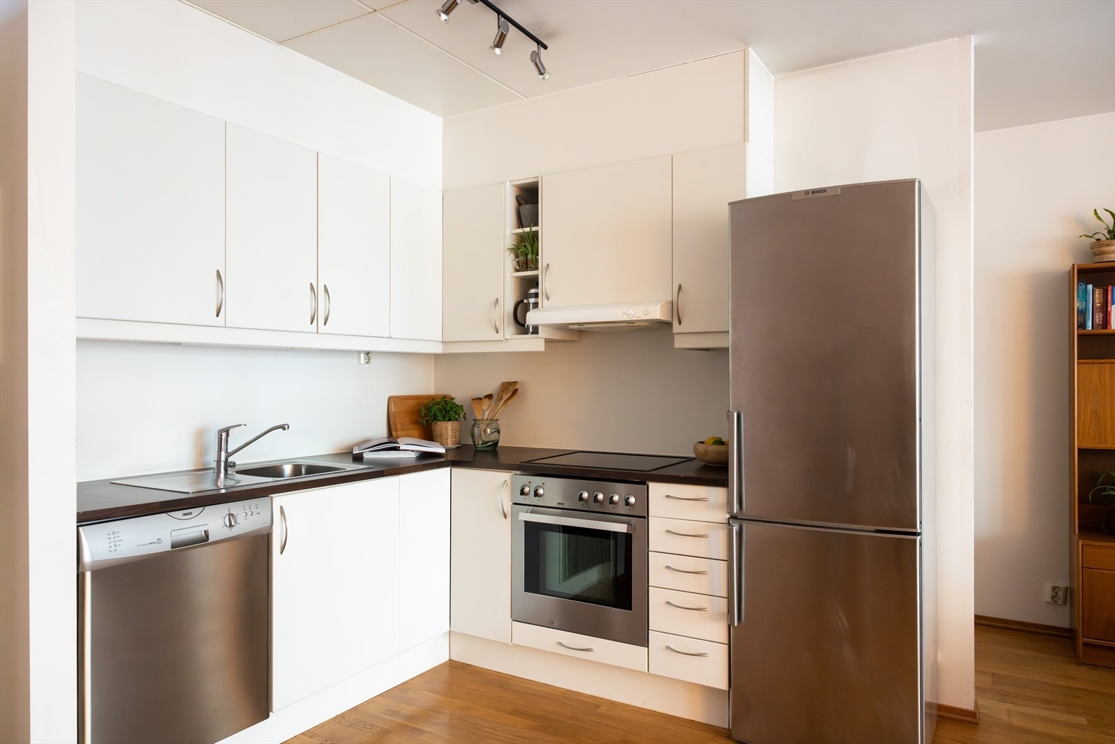 - Kjøkkeninnredning med glatte fronter. Laminat benkeplate med nedfelt vaskekum. Belysning over benkeplaten - Galleribilde