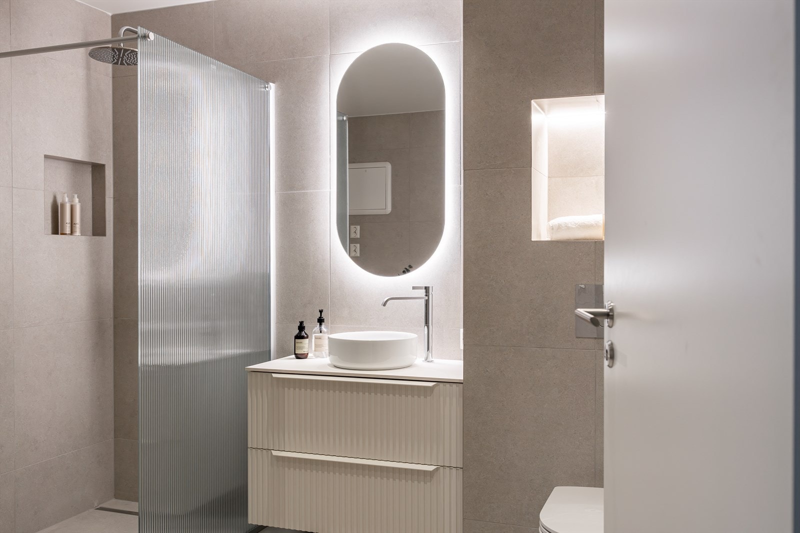 Badet er nylig pusset opp med innebygde hyller, store lekre fliser og moderne barderomsinnredning. Legg merke de små detaljer som lys i innebygd hylle, som gir en eksklusiv følelse! Galleribilde