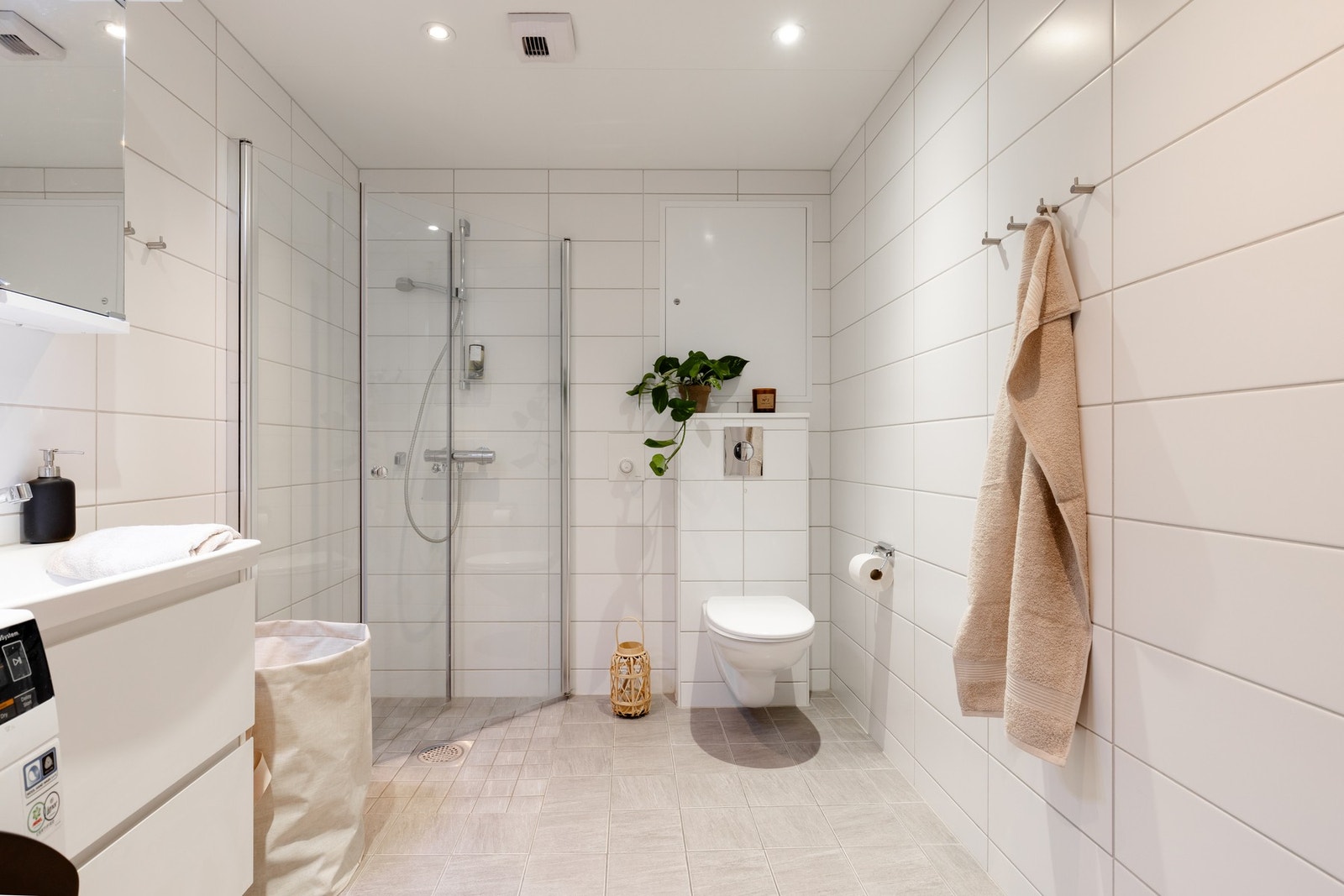 Badet har en stilren innredning med nedfelt servant, samt speil på vegg. Dusjhjørne med glassdører og vegghengt toalett. Galleribilde