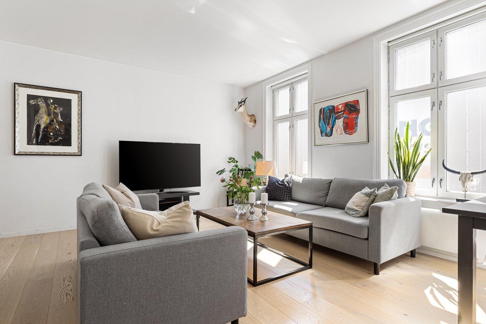 Stuen og resten av leiligheten ble oppusset i 2019. De store vindusflatene gir mye naturlig lysinnslipp. Galleribilde