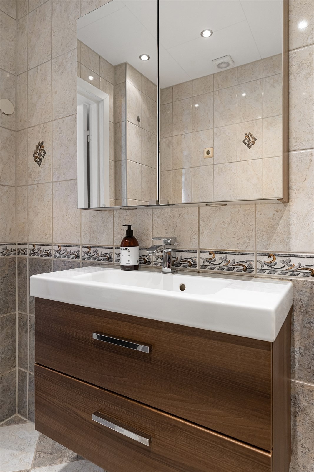 Stor vask med overhengt speilskap med lys. Galleribilde