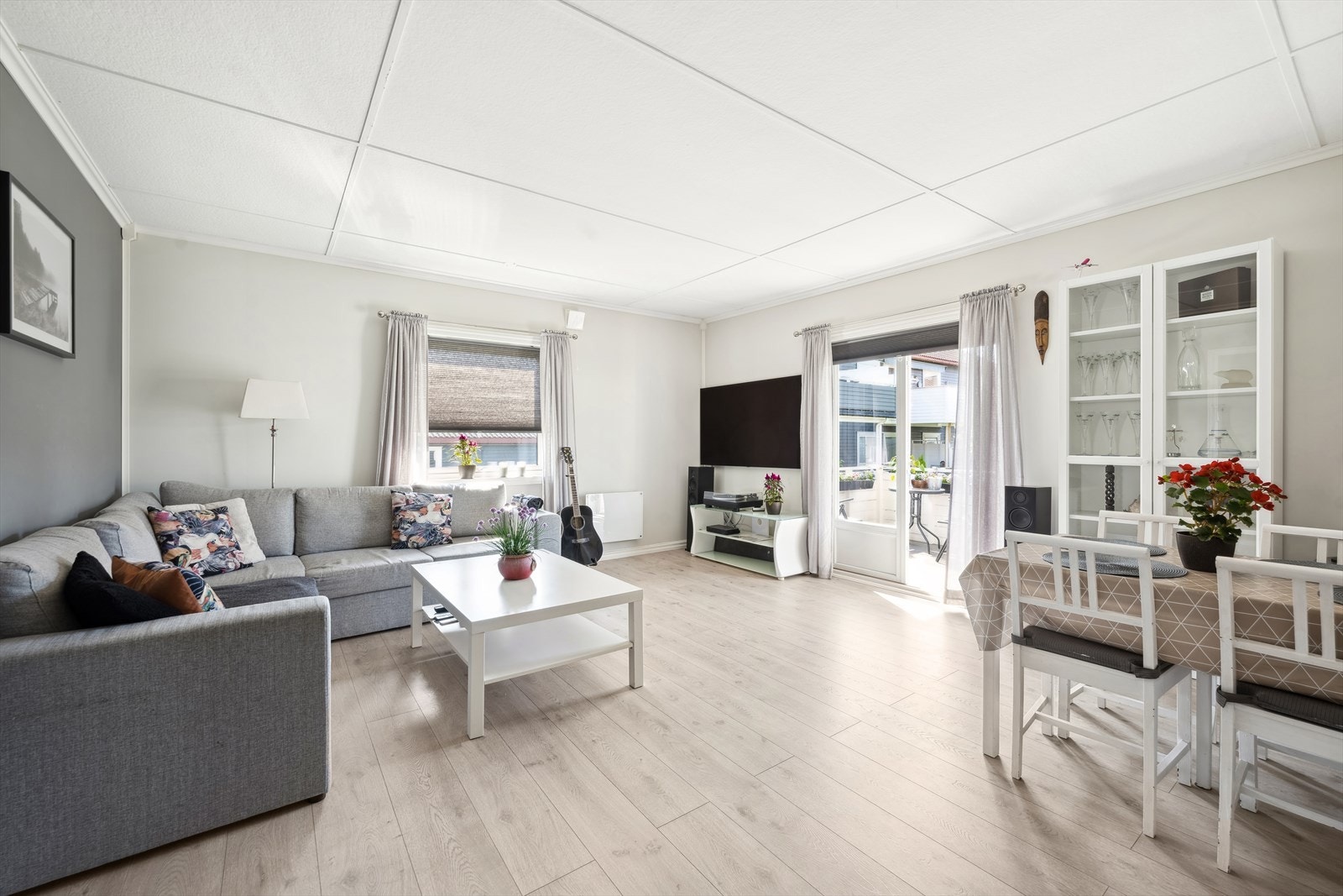 Stuen er i likhet med resten av leiligheten koselig med hvitmalte vegger foruten en vegg og laminatgulv. Galleribilde