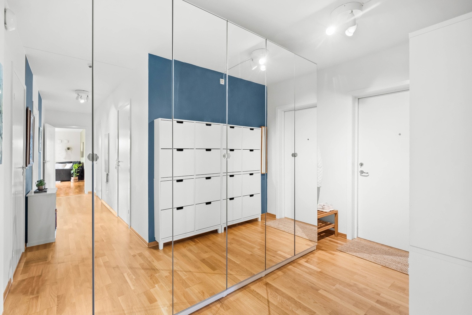 Leiligheten har en innbydende entré med gode opphengsmuligheter for yttertøy i stor skyvedørsgarderobe langs den ene veggen, samt skoskap langs den andre Galleribilde