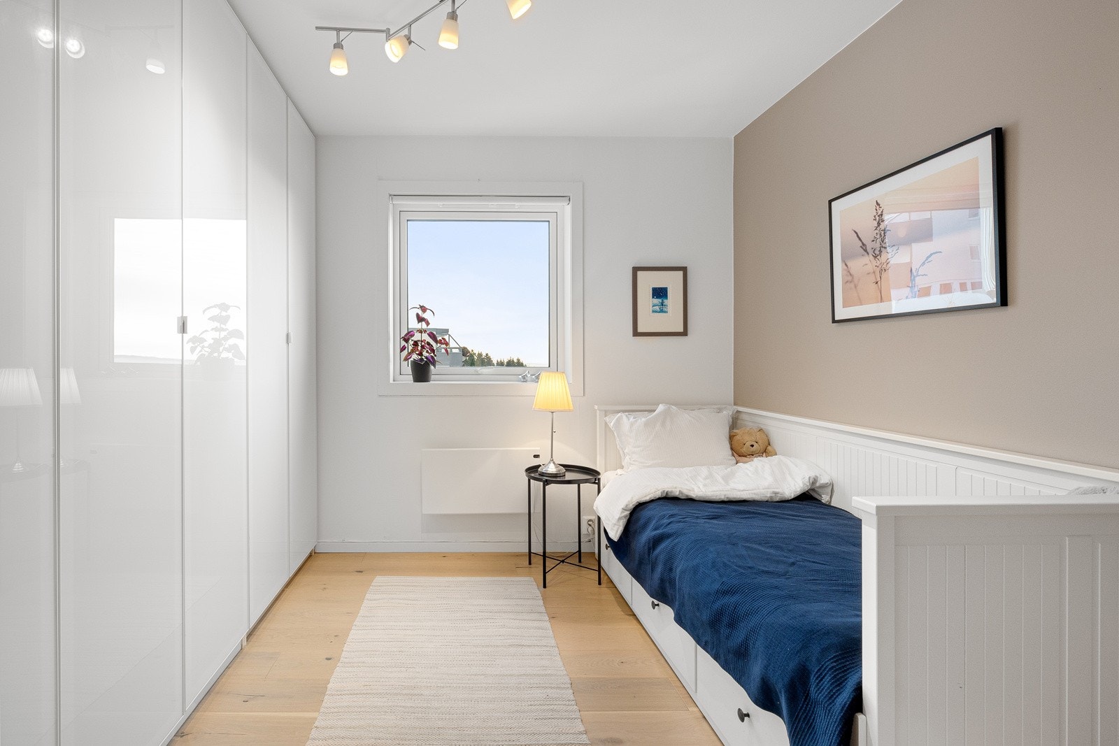 Det andre soverommet med adkomst fra stuen har en hel garderoberekke med hvite høyglansfronter. Galleribilde