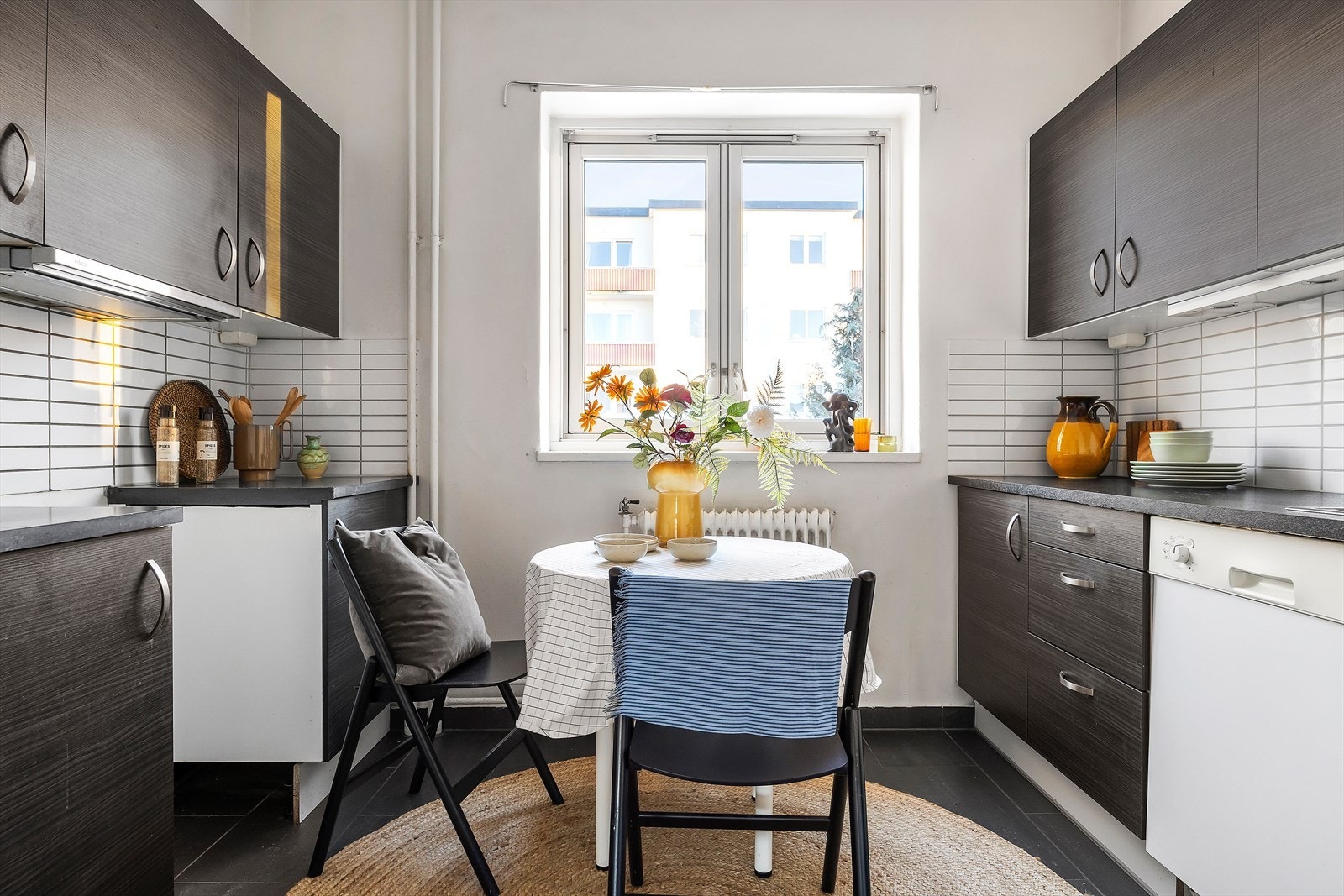 Mørk kjøkkeninnredning med glatte fronter og benkeplate av laminat. Oppvaskmaskin medfølger salget. Galleribilde