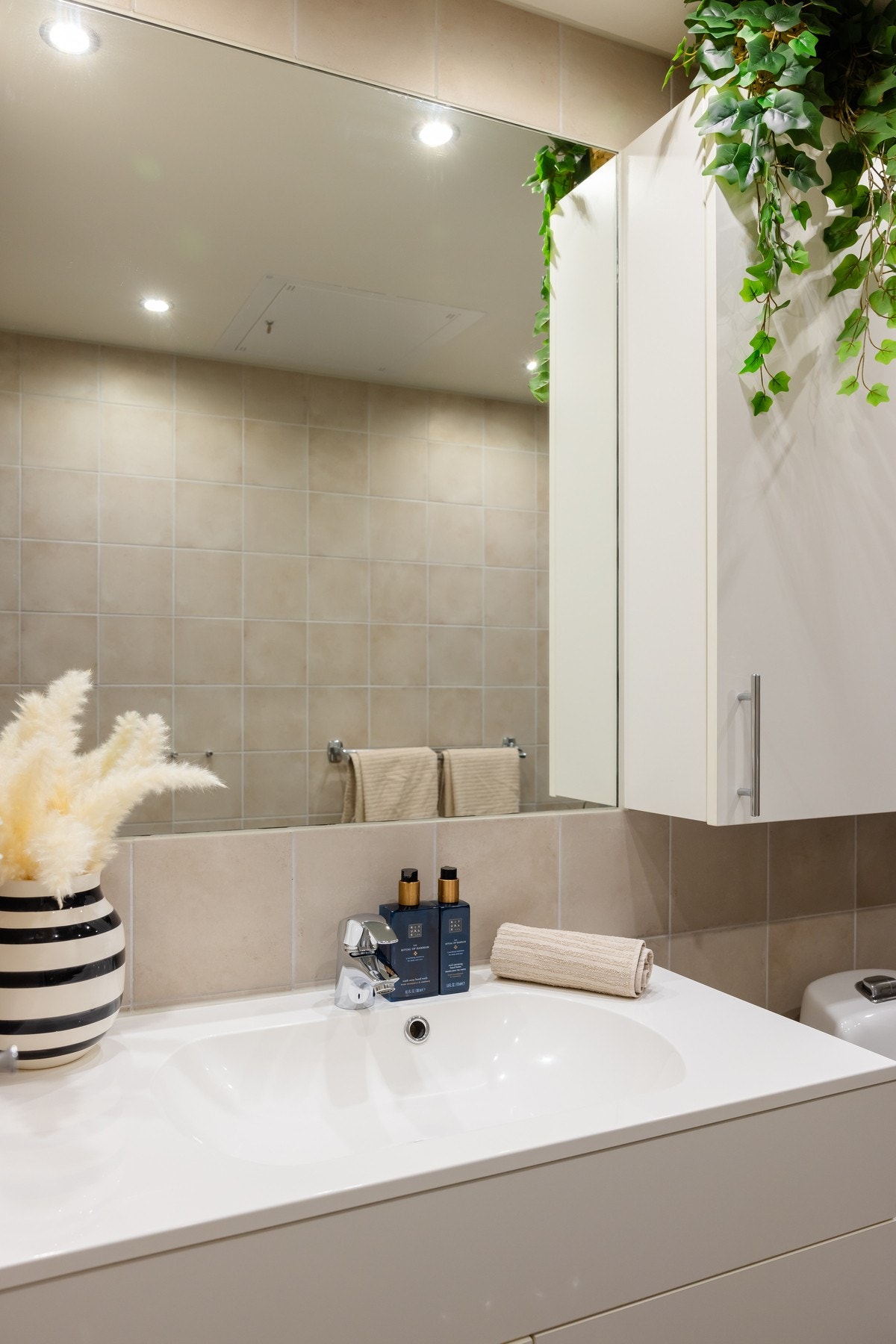 Innredningen består av servant på underskap, overskap, speil og vegghengt toalett. Galleribilde