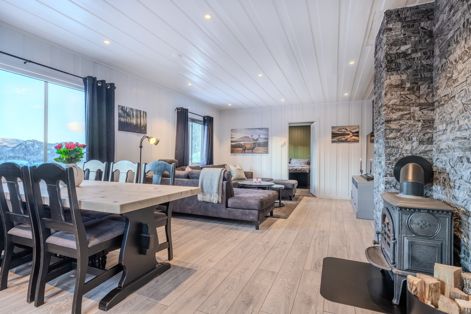 Koselig kombinert stue og spisestue utstyrt med peisovn. Galleribilde