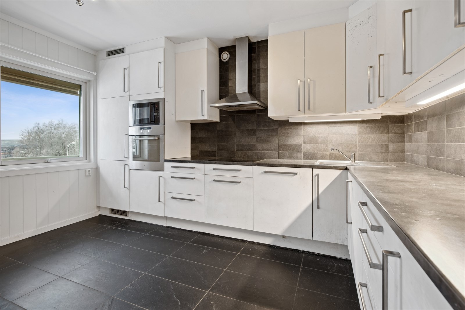 Takhøy kjøkkeninnredning med godt med skapplass og integrerte hvitevarer. Galleribilde