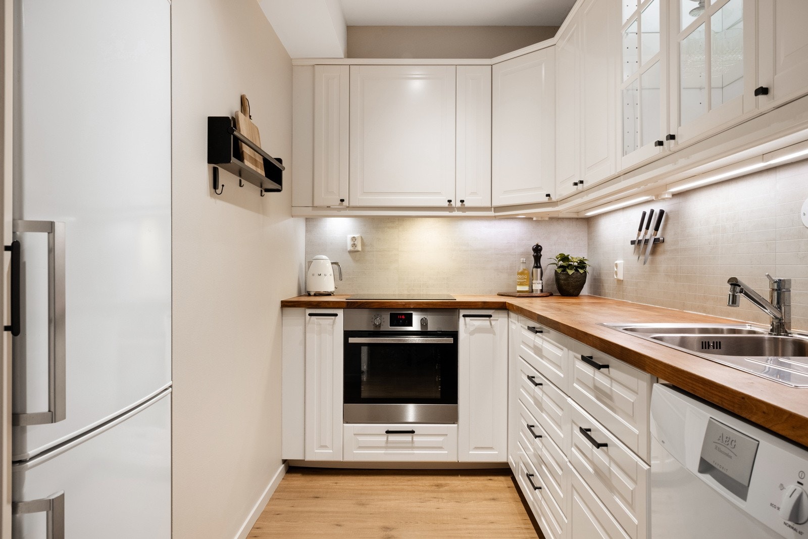 Kjøkkenet fremtsår tidsriktig og moderne, og består av hvite fronter og benkeplate av tre. Galleribilde