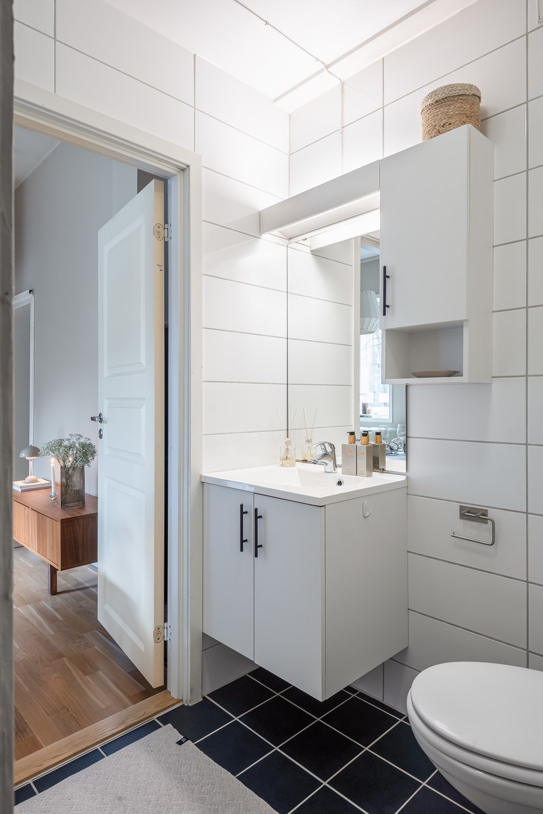 Videre er badet innredet med servantskap med overskap og speil med lys samt vegghengt toalett. Galleribilde