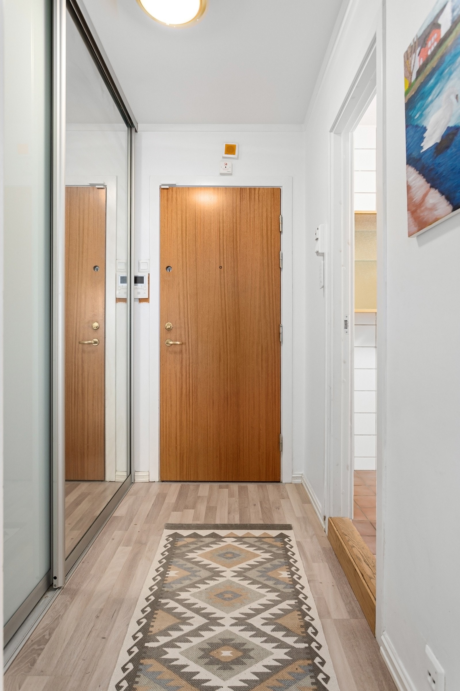 Romslig og lys entré/gang med stor skyvedørsgarderobe til oppbevaring av sko- og yttertøy. Galleribilde