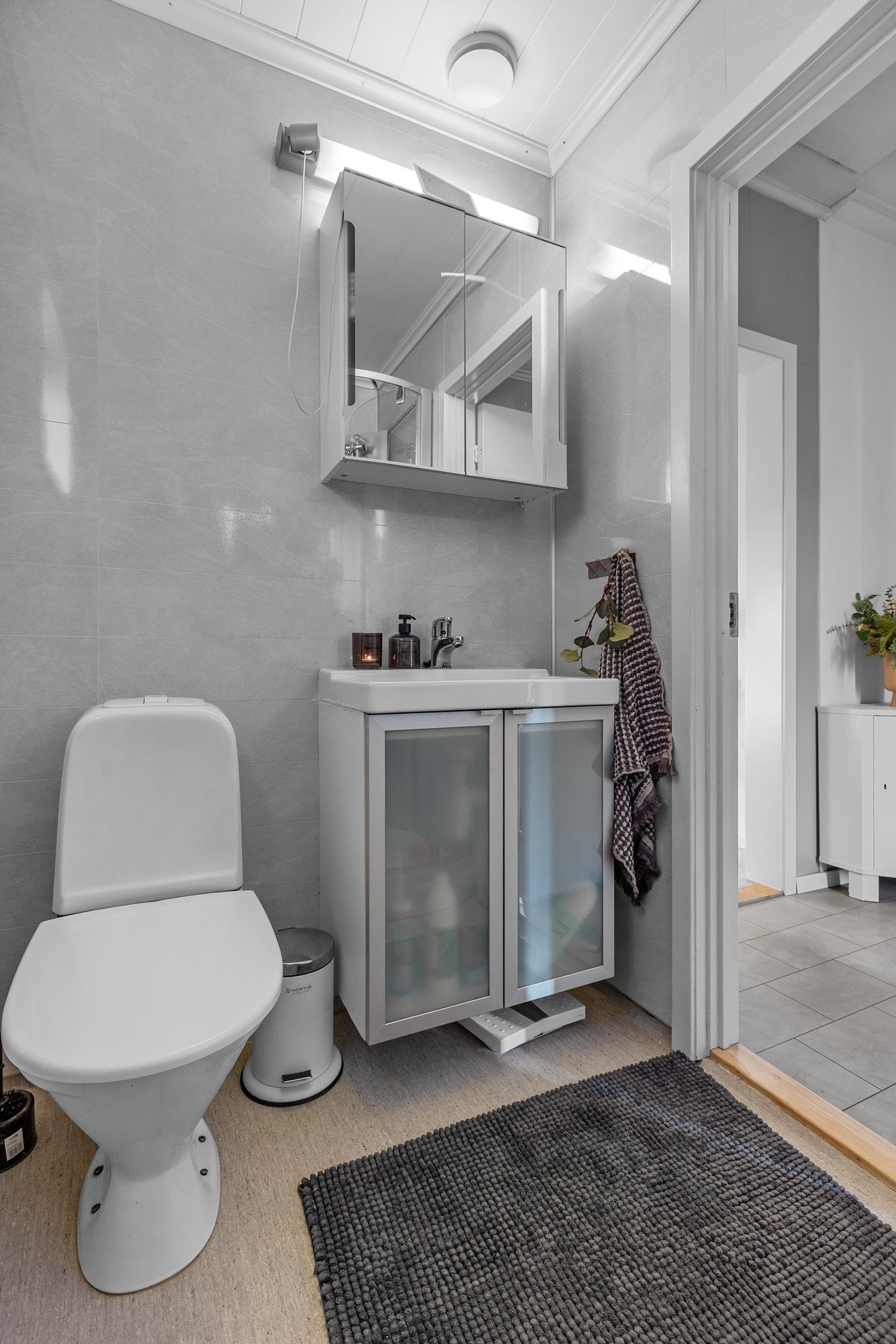 Badet er innredet med servant, speilskap med belysning, toalett og dusjkabinett Galleribilde