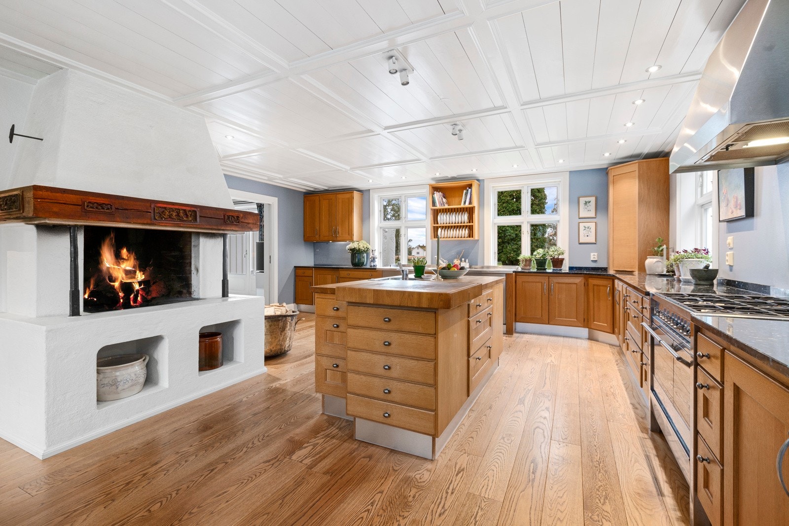 Kvänum eikekjøkken med Larvikitt benkeplater og en plassbygget peis Galleribilde