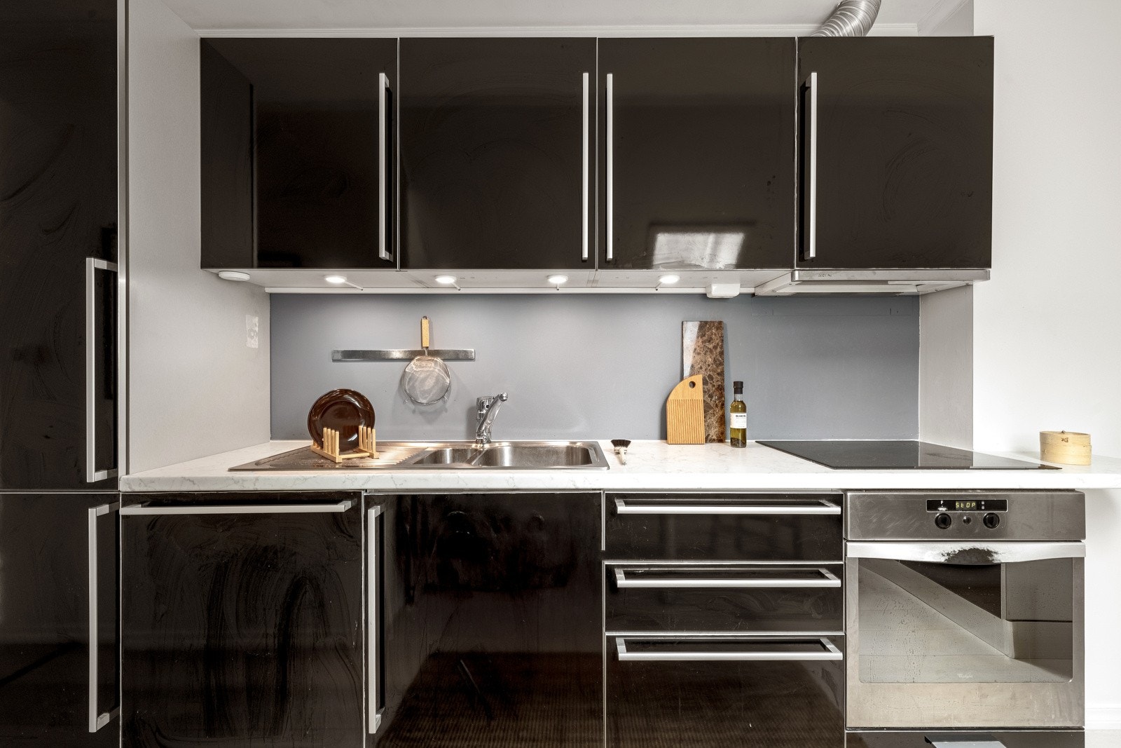 Integrerte hvitevarer på kjøkkenet er stekeovn, platetopp, ventilator, oppvaskmaskin og kjøleskap med frysedel. Galleribilde