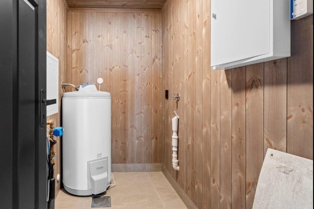 Teknisk rom/bod med varmtvannsbereder, fordelerskap og opplegg for vaskemaskin Galleribilde