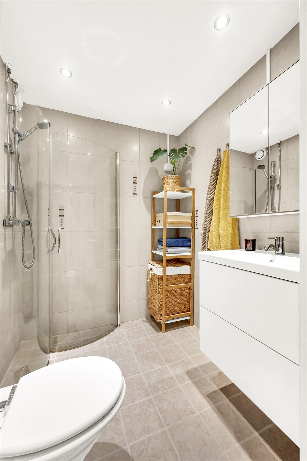 Badet er utstyrt med klosett, servant nedfelt i innredning og et praktisk dusjhjørne med svingbare glassdører. Galleribilde