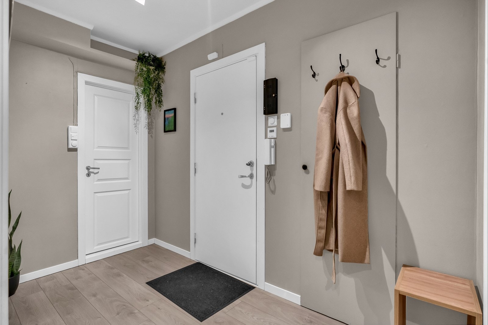 Leiligheten har en fin og innbydende entré, med plass til å henge fra seg yttertøy og sette fra seg sko. Galleribilde