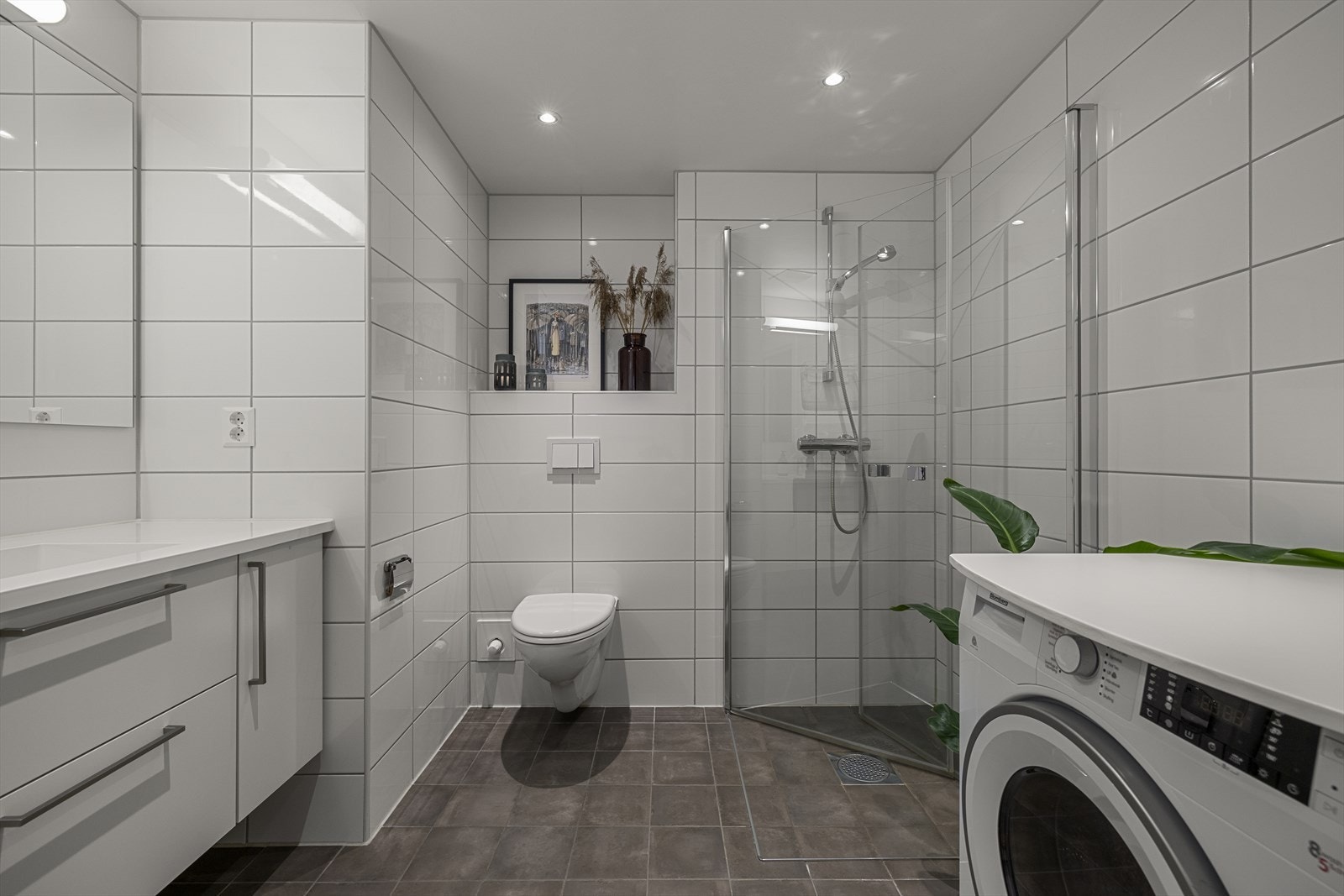 Boligen har et vakkert flislagt bad med lys innredning, gulvvarme og downlights i taket for en moderne og behagelig belysning. Galleribilde