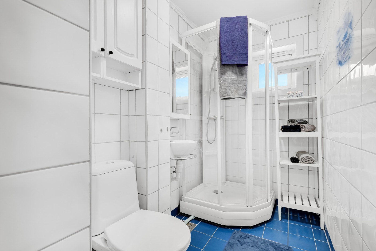 Flislagt bad med varmekabler i gulv. Det har blitt dusjet i dusjkabinett. Galleribilde