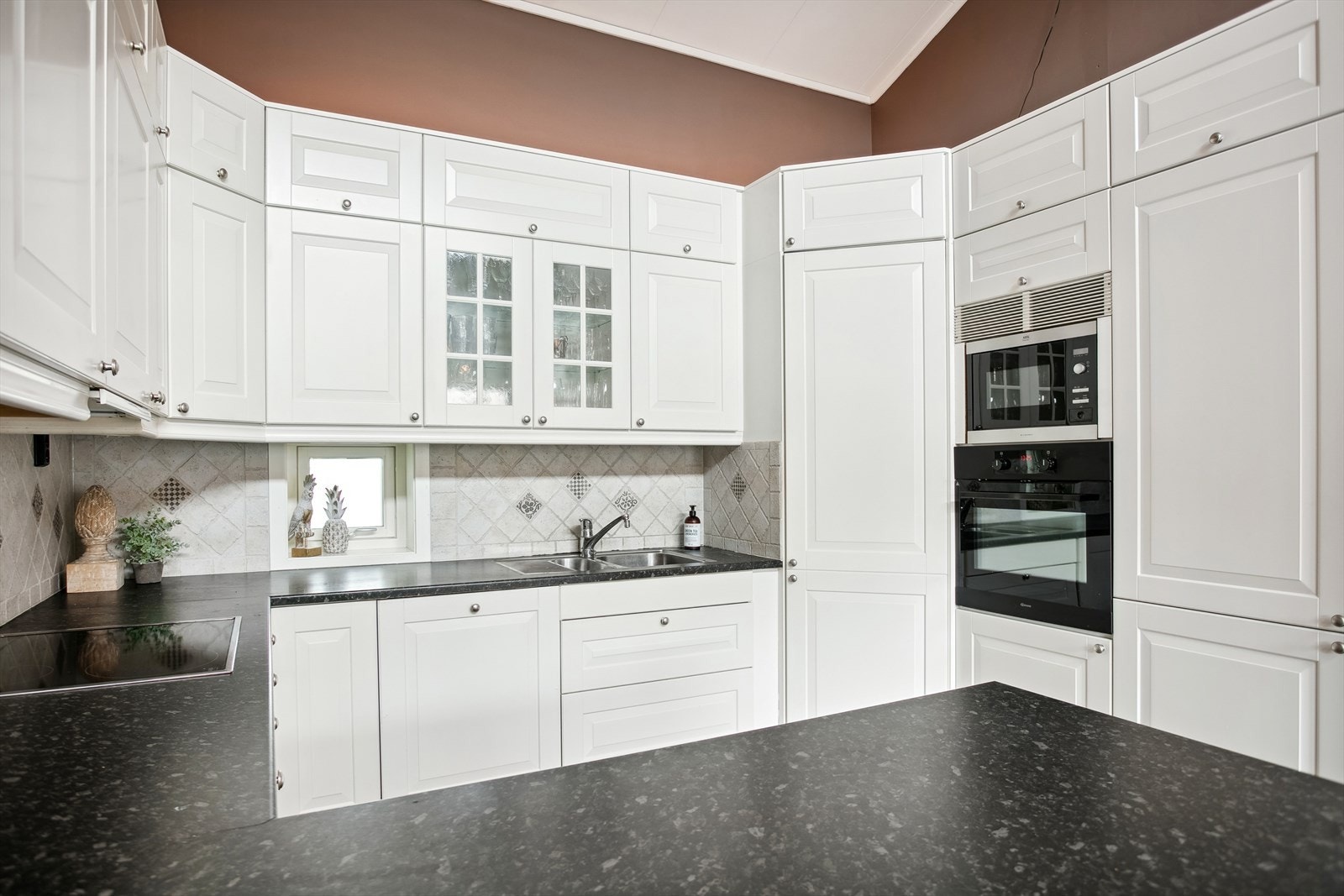 Kjøkkenet har god skap- og benkeplass, samt integrerte hvitevarer Galleribilde