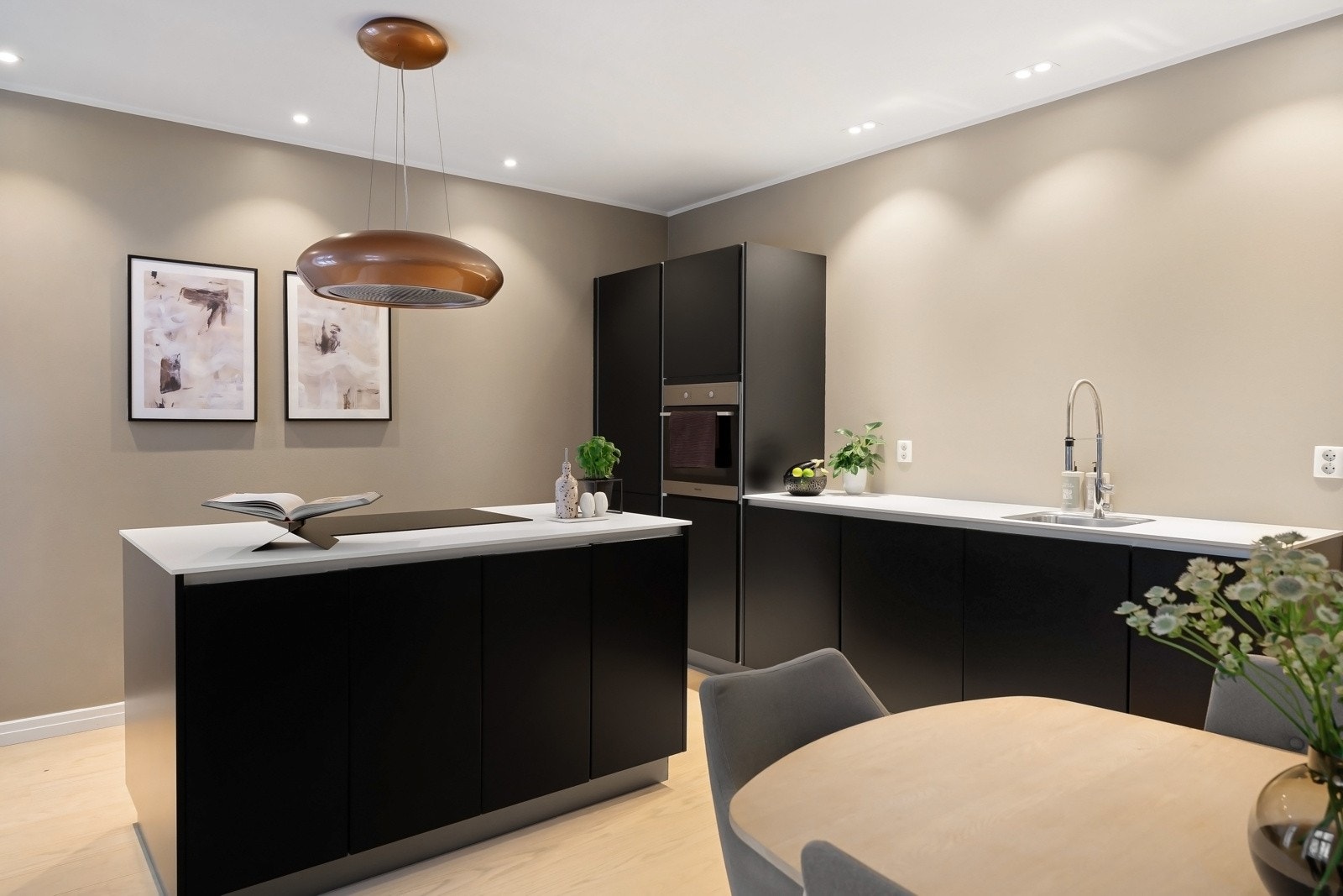 Kjøkkenet har en moderne innredning med kjøkkenøy og integrerte hvitevarer Galleribilde