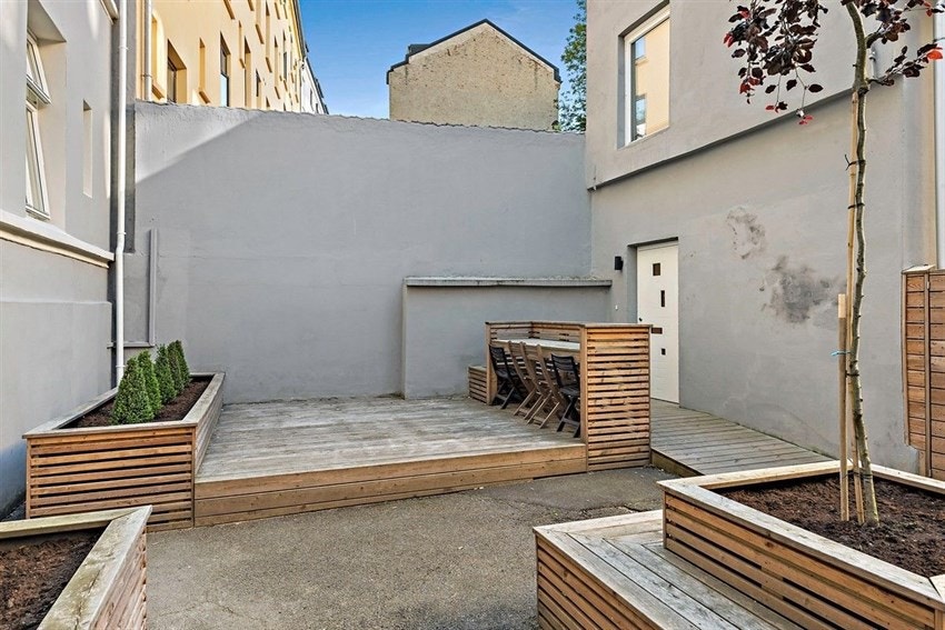 Den skjermede og trivelige bakgården byr på sykkelparkering og sittegrupper Galleribilde