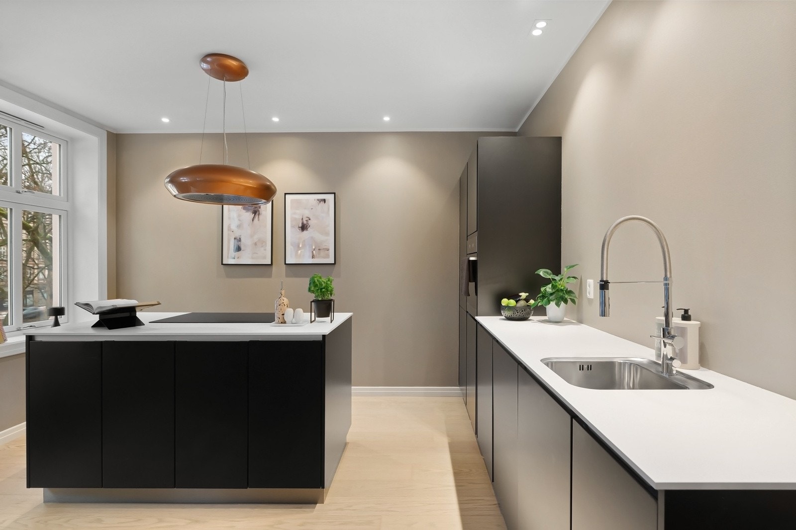 Kjøkkenet er fra KVIK med glatt kjøkkeninnredning og hvit benkeplate Galleribilde