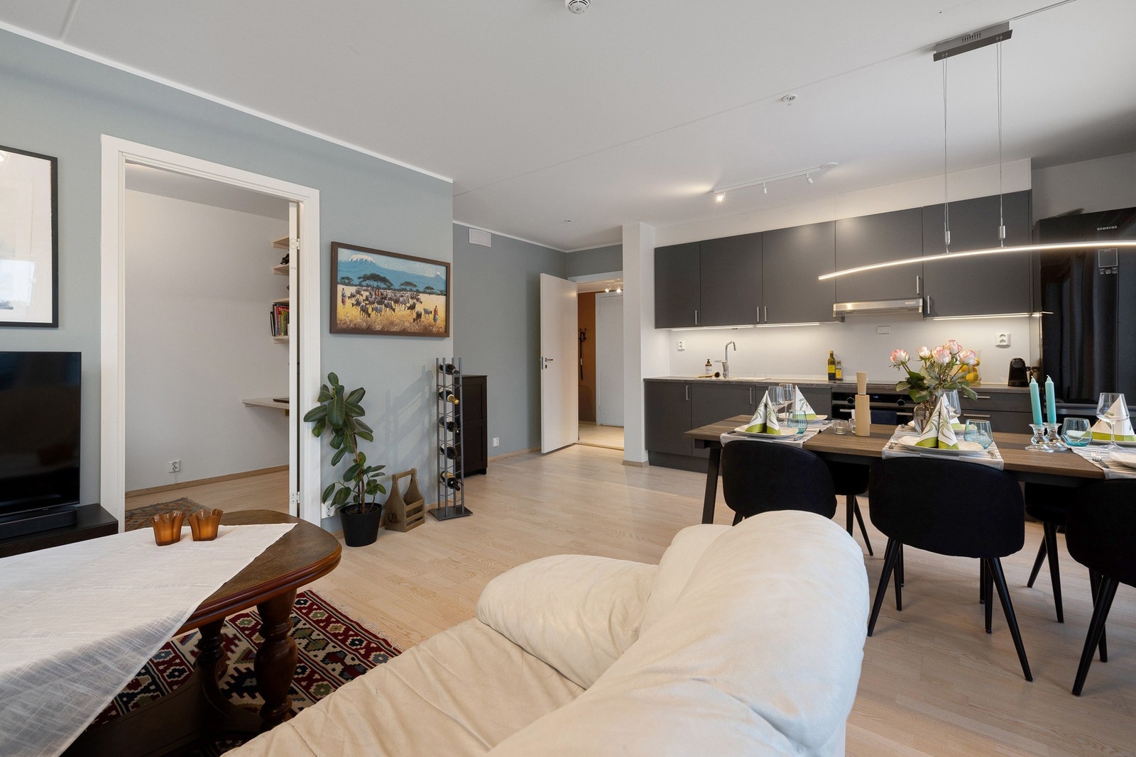 Moderne og gjennomført stue med åpen løsning mot kjøkkenet, godt med plass og en harmonisk fargepalett. Galleribilde