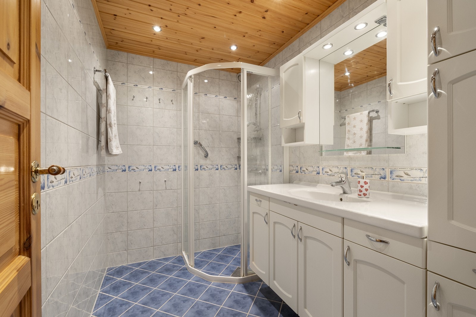 Flislagt bad innredet med nedfelt servant og hjørnedusj. Galleribilde