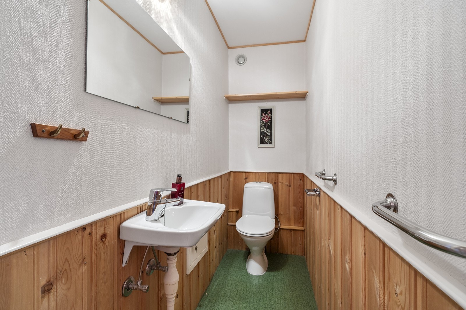 Enkelt toalettrom med vegghengt servant. Galleribilde