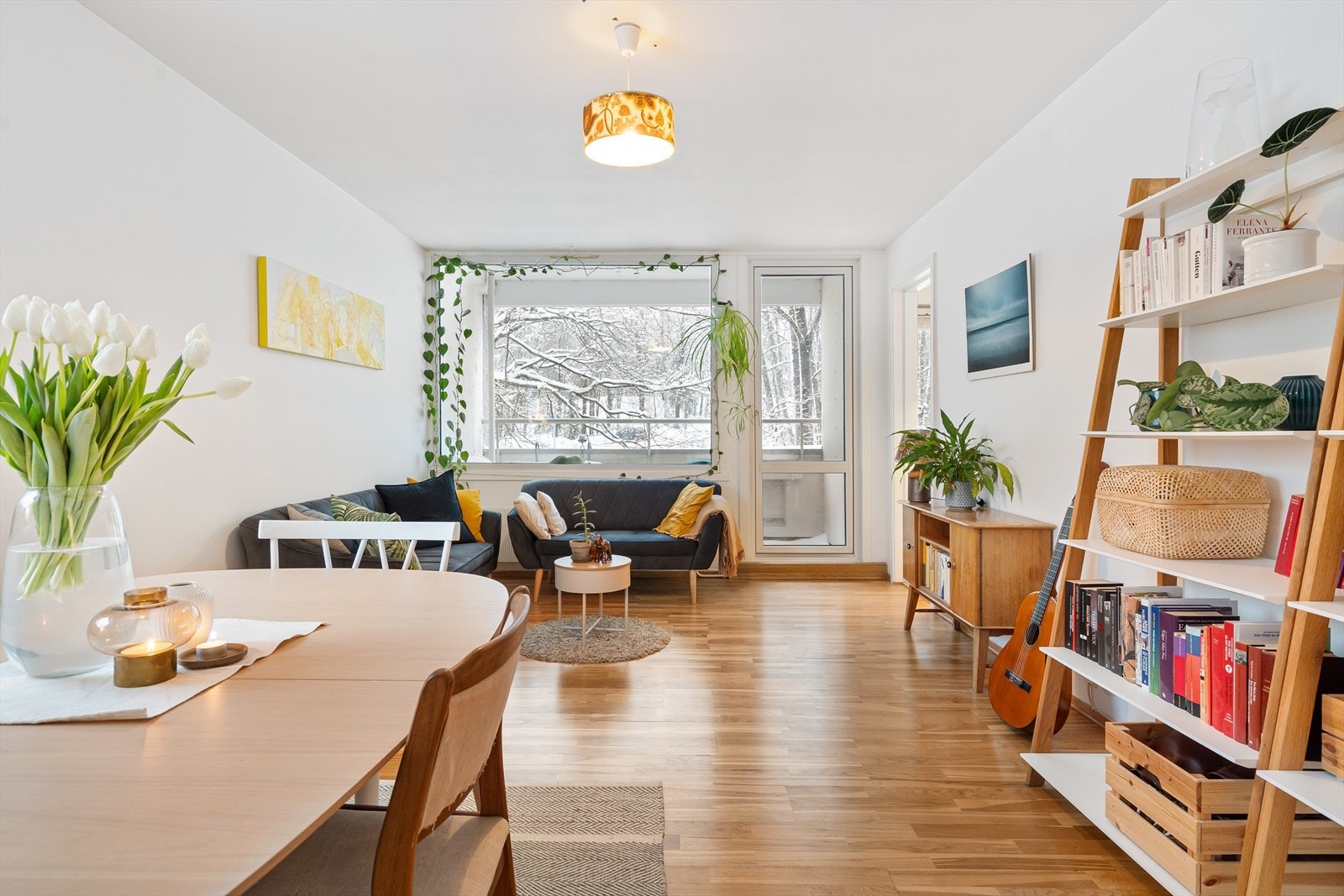 En lys og romslig stue med god plass til sofa, stuebord, spisebord og stoler, samt annet møblement Galleribilde