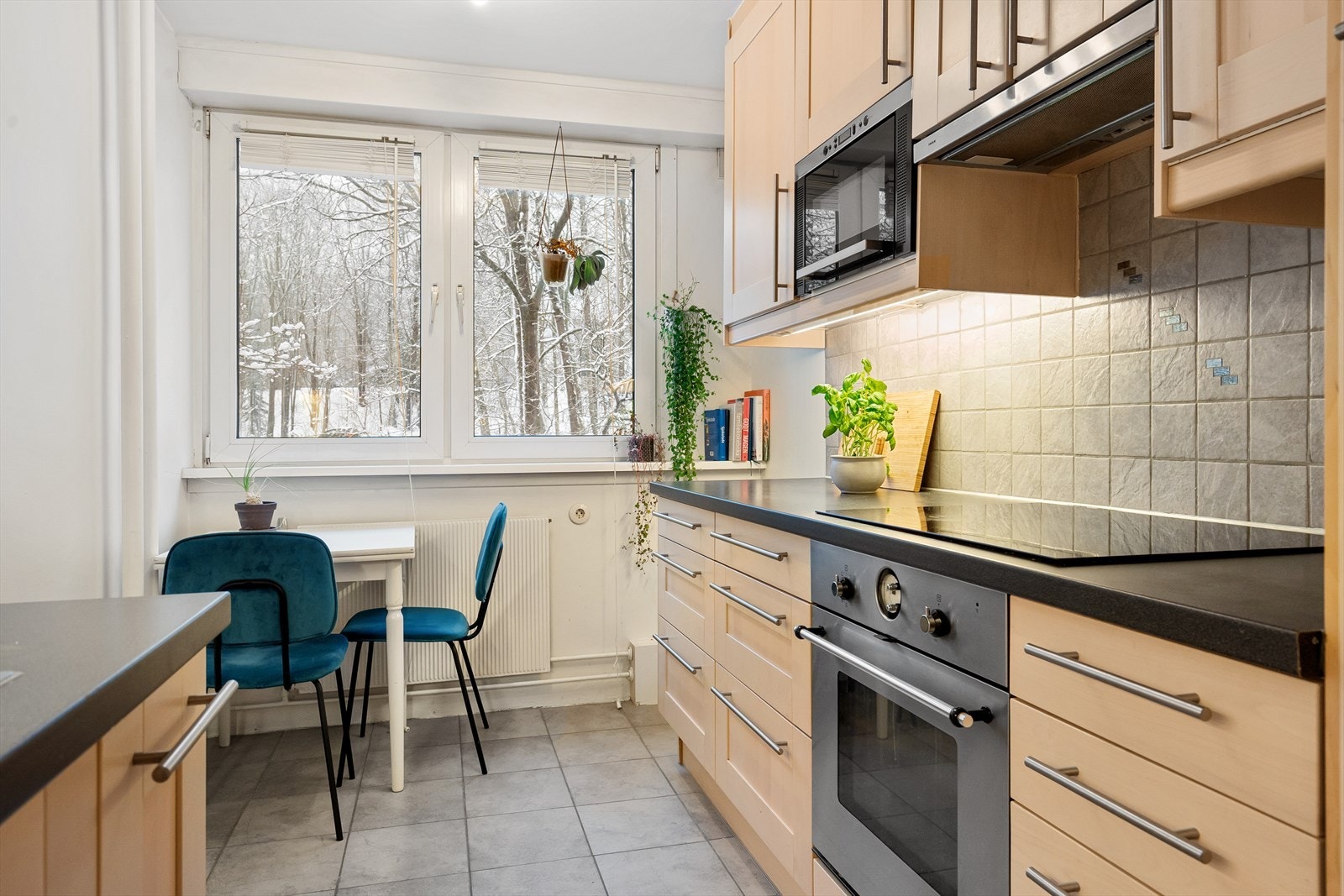 Kjøkkeninnredning med profilerte fronter, laminat benkeplate, fliser mellom overskap og benk. Galleribilde