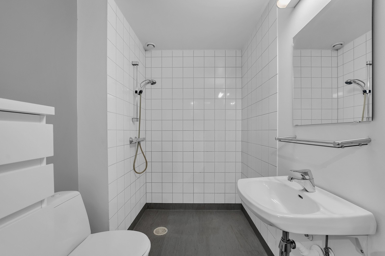 Badet har belegg på gulv. Det er også varme i gulvene. På veggene er det en kombinasjon av malte flater og fliser. Galleribilde