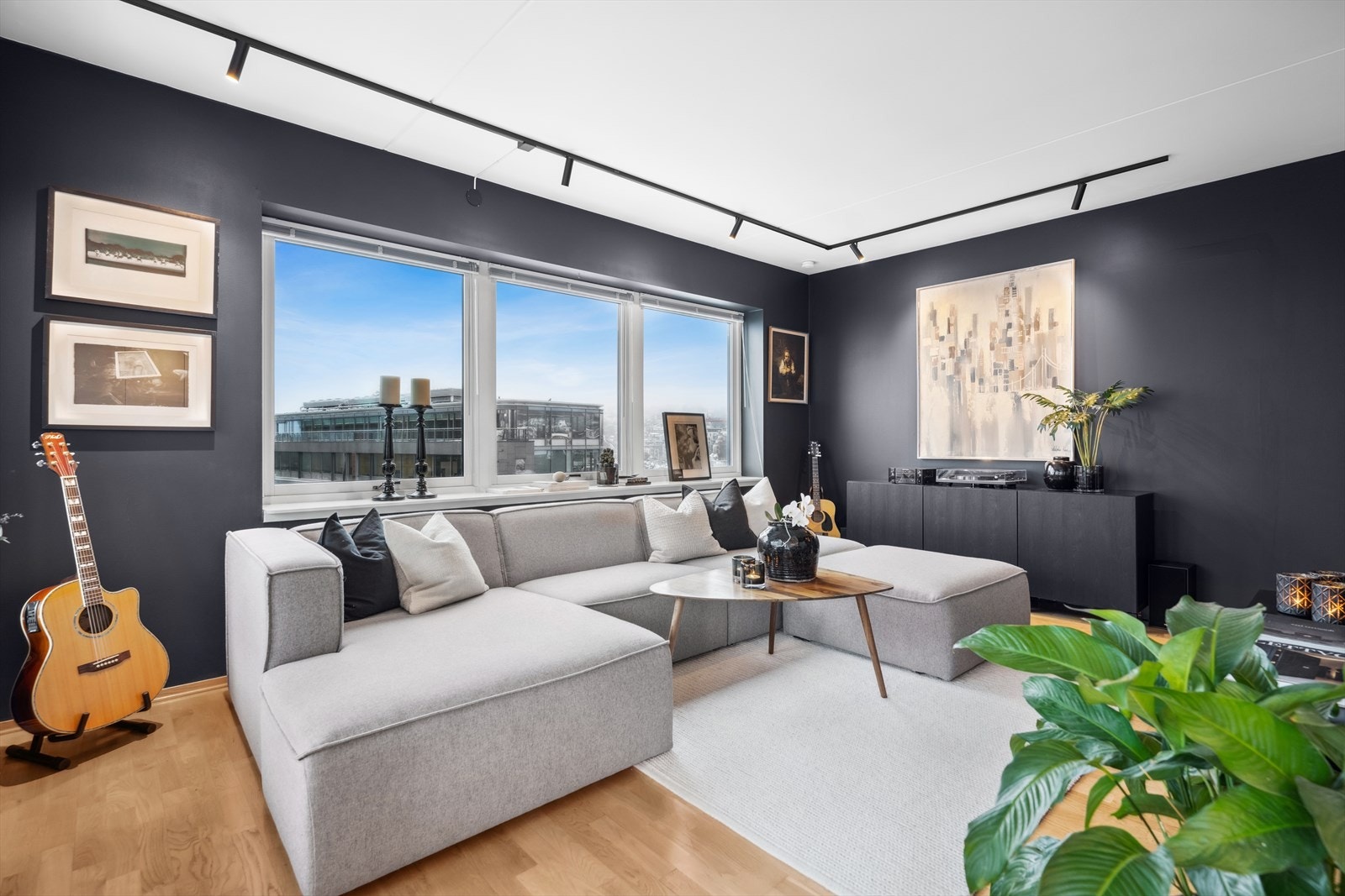 Stuen er moderne med vegger malt i en dyp, mørk farge. Galleribilde