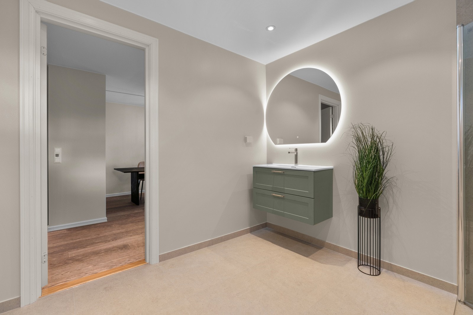 Badet har enkel tilgang fra midt i leiligheten. Det er moderne og tidløst med dusjnisje med innfellbare glassdører. Galleribilde