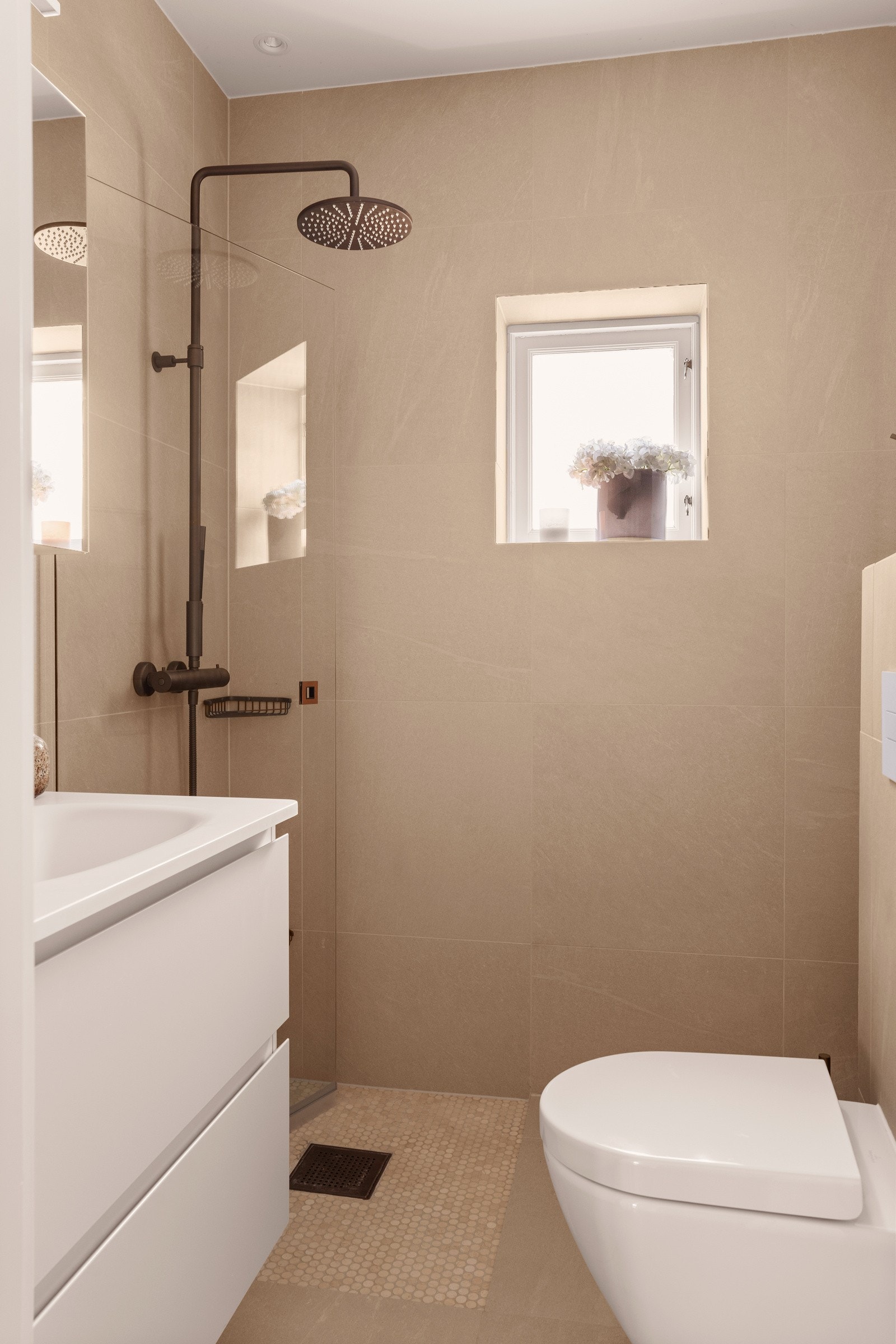 Badet er utstyrt med gulvvarme og fremstår delikat med store, lyse fliser på både vegger og gulv. Flisene er noe lysere i virkeligheten. Alt levert fra Ulfven Galleribilde