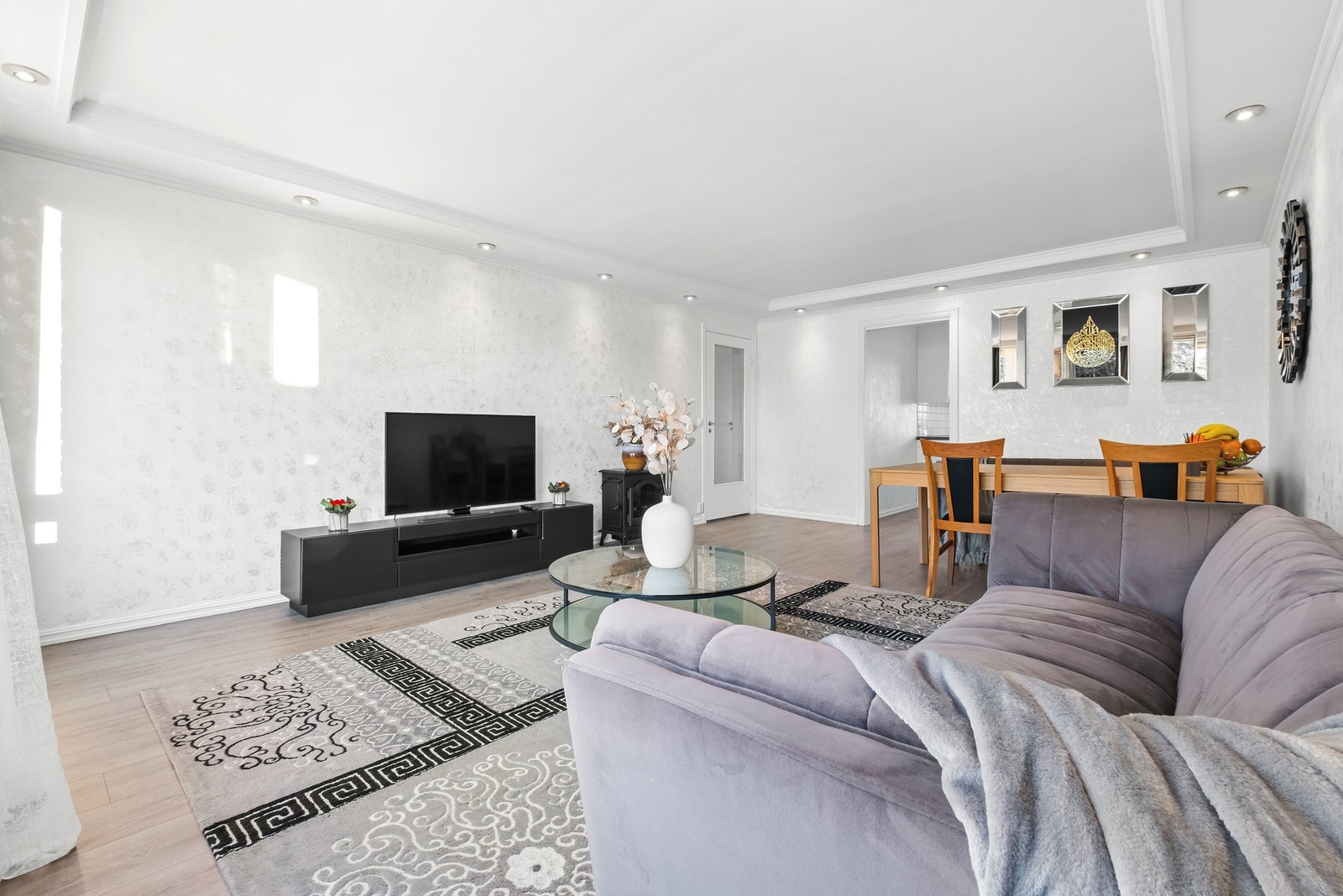 Inn til boligens flotte oppholdsrom. Her har du nedsenket himling med downlights og flotte vegg- og gulvflater Galleribilde