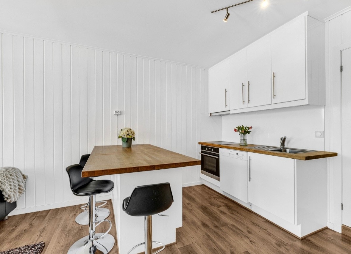 Her er det også en fin sitteløsning på kjøkkenøyen som skaper et sosialt kjøkkenområde Galleribilde